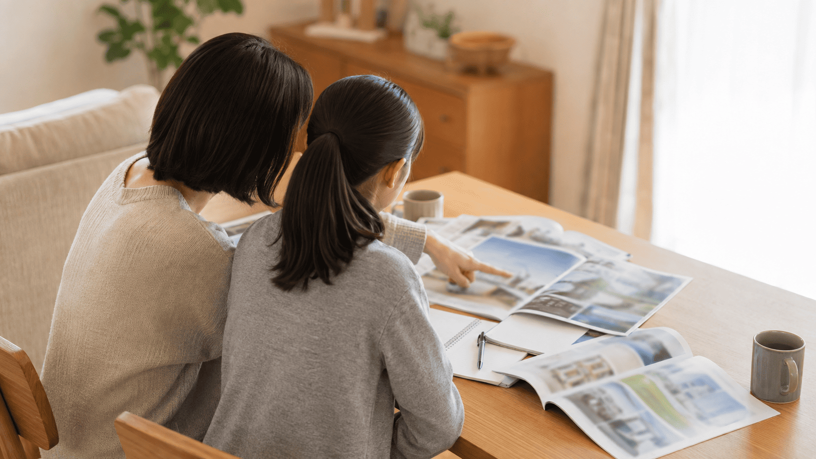 学校の資料を見ながら進路を話し合う親子